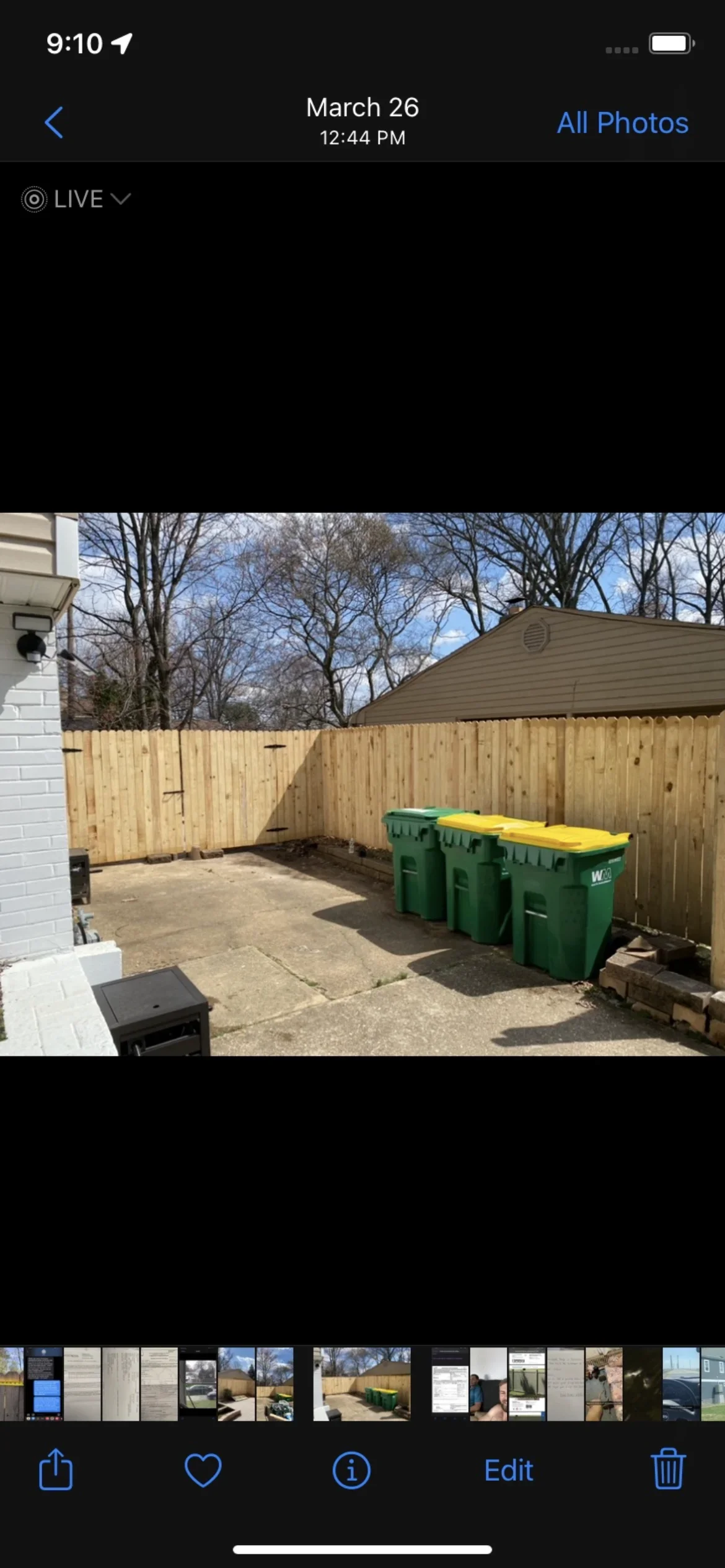Newly installed wood privacy fence with vertical boards and black hardware in residential backyard