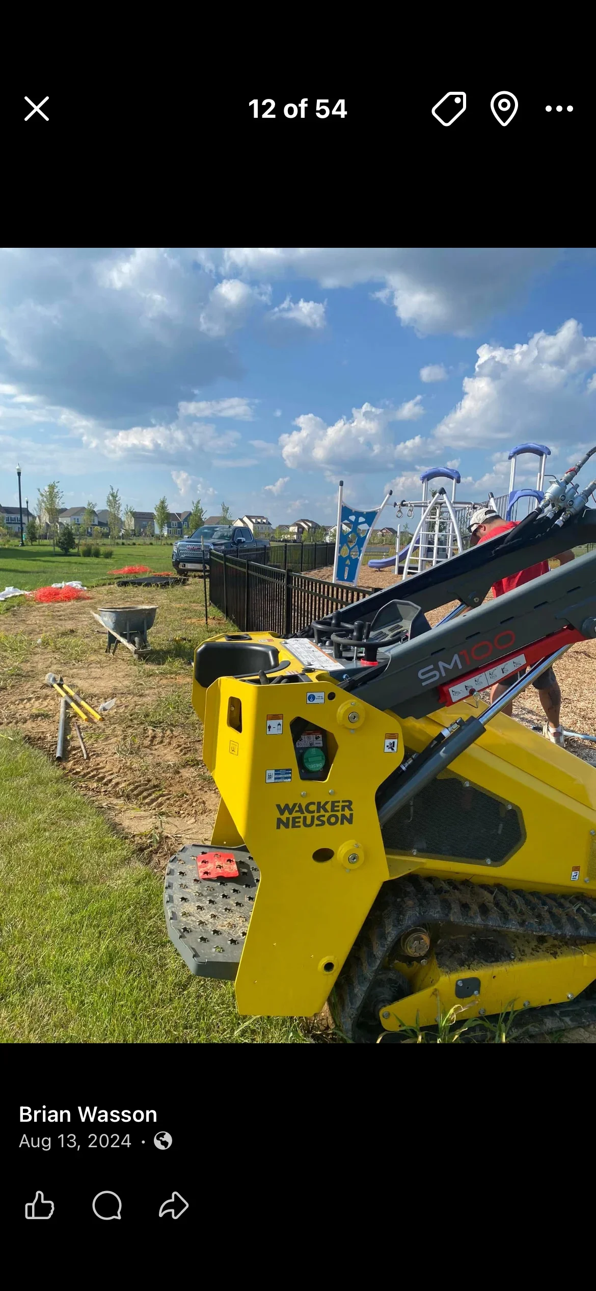 Yellow Wacker Neuson track loader with black vinyl fence materials staged for residential installation